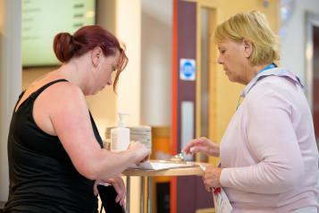 Two women talking and completing a survey